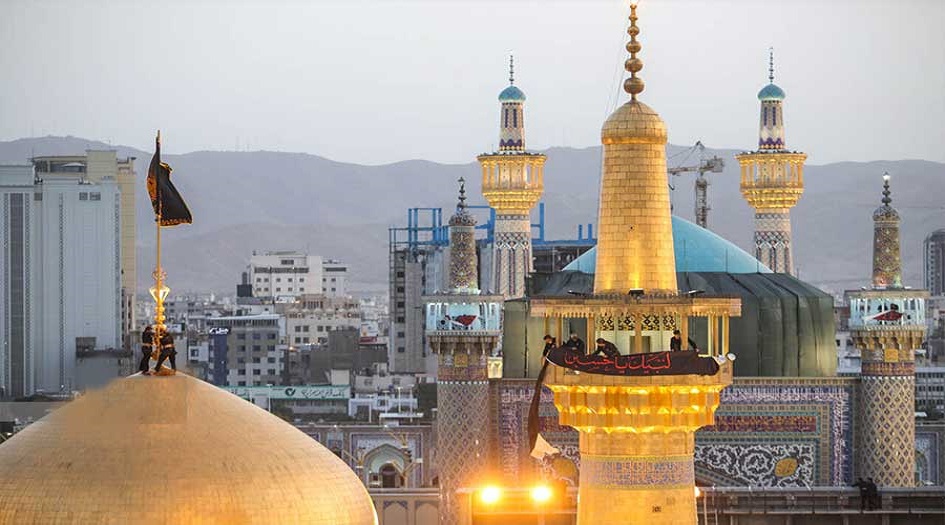 بالصور... رفع راية العزاء الحسيني والحداد فوق قبة ضريح الإمام الرضا والسيدة المعصومة "عليهما السلام"