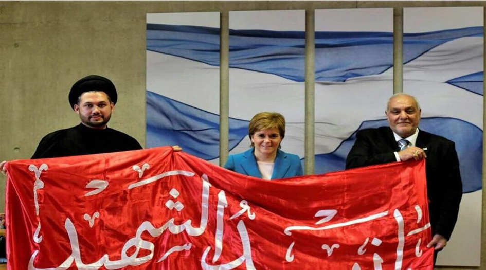 رئيسة وزراء اسكتلندا تطلب صورة مع راية الإمام الحسين +صورة